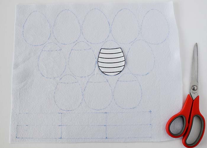 Schneiden Sie die obere Form des Musters aus, legen Sie sie auf eine der zu bestickenden Formen und ziehen Sie die Linie