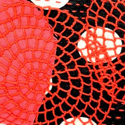 Rote Deckenstiche, gefüllt mit Kreisen auf schwarzem Stoff