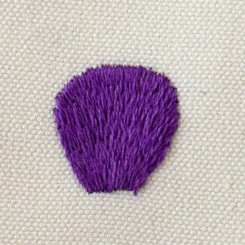 Long and Short stitch embroidery with purple threads on white fabric
