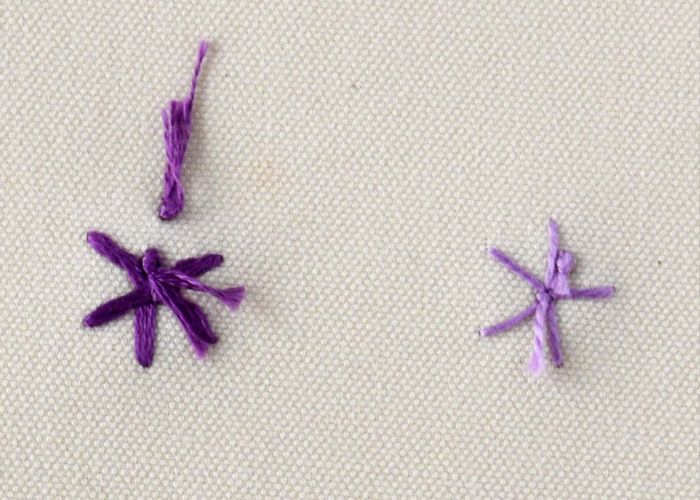 Gepeitschte Spinnenrad-Stickerei mit lila Fäden auf der Rückseite