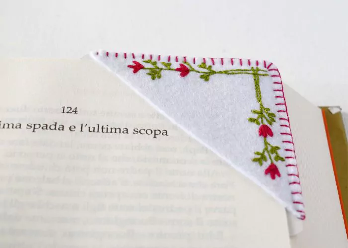 Handgesticktes Ecklesezeichen mit minimalistischen Blumen auf einem Buch